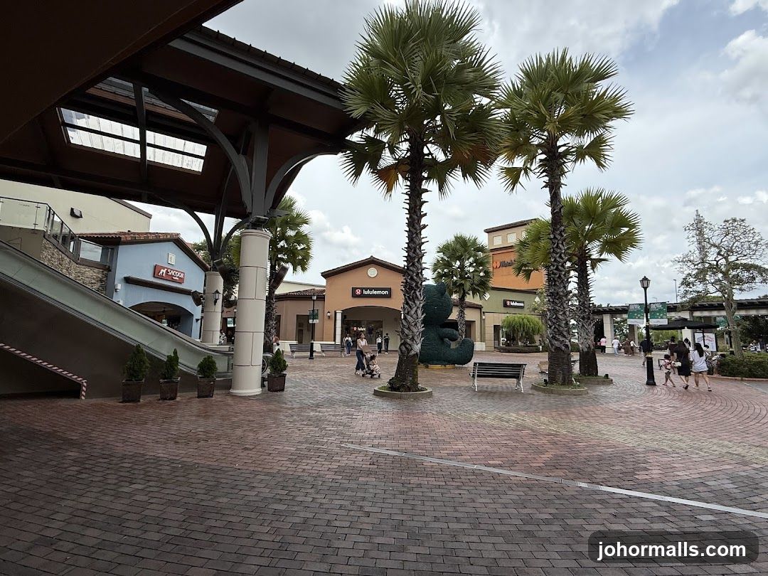 Outdoor shopping area with palm trees and shops