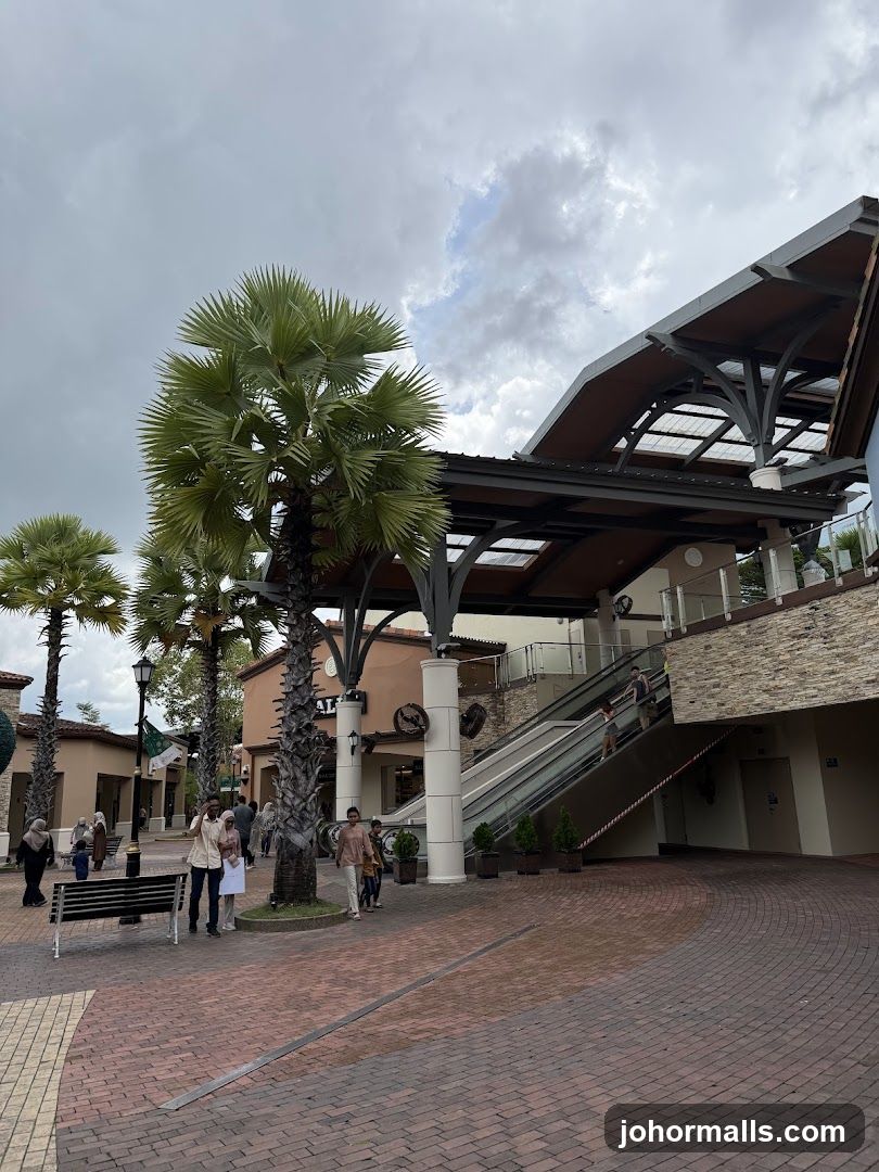 Outdoor shopping area with palm trees and escalators