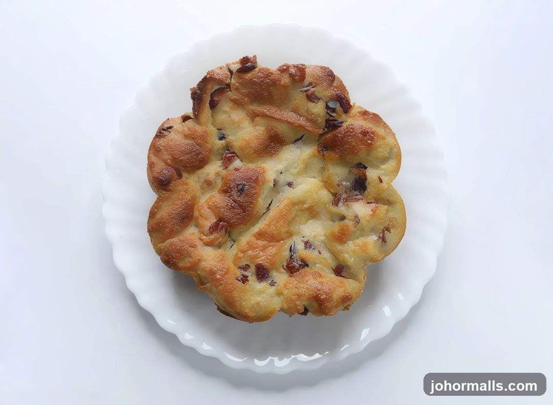 Flower-shaped pastry with raisins on a white plate