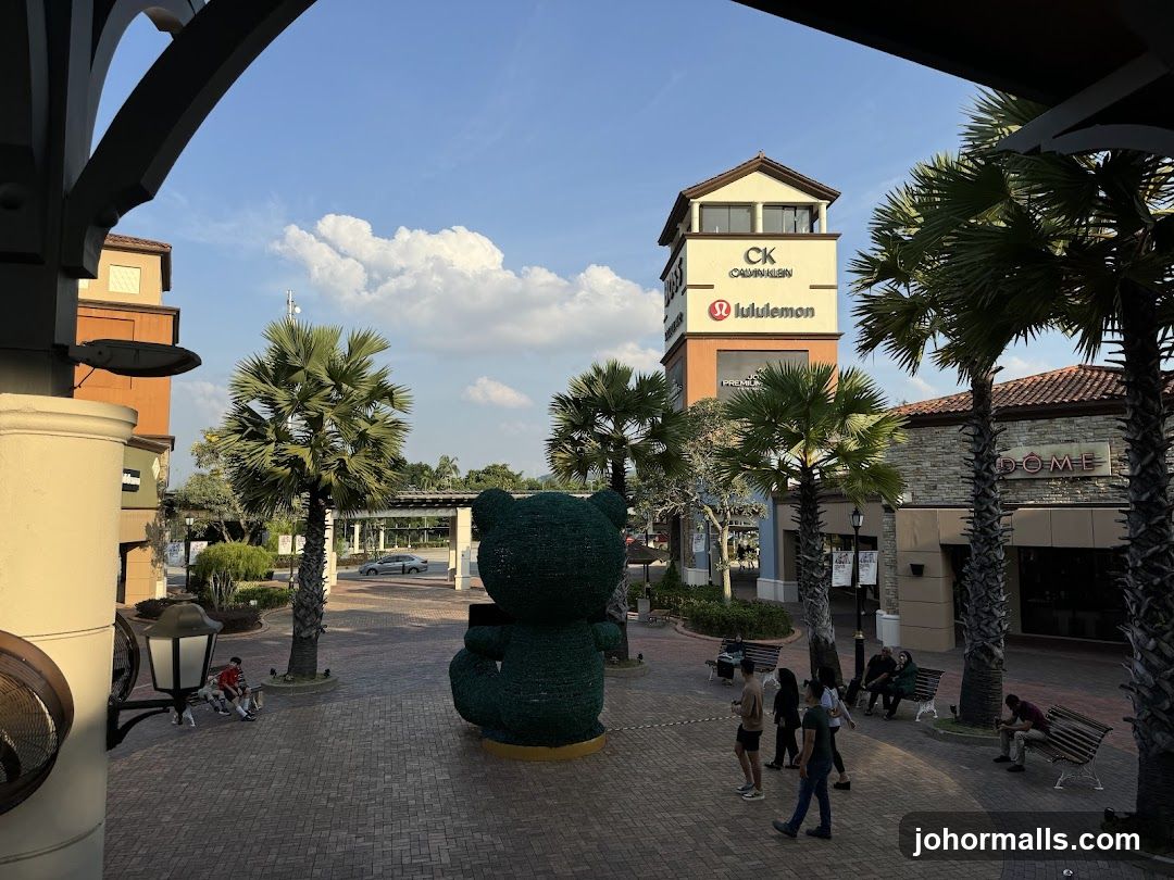 Outdoor shopping area with a large teddy bear sculpture