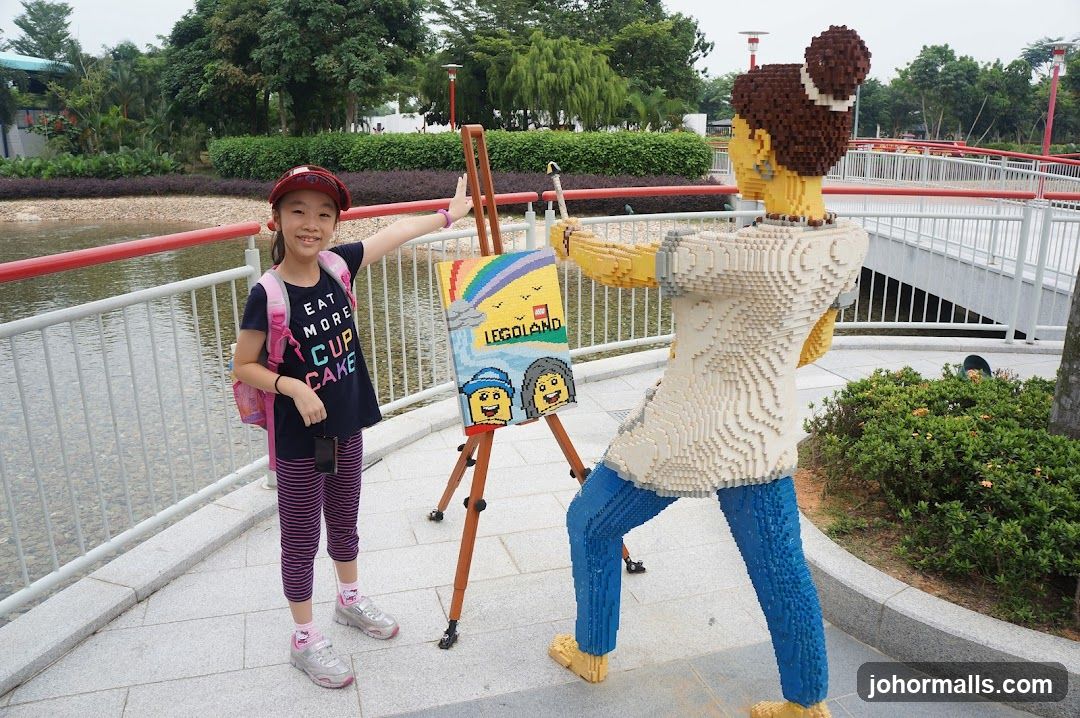 Girl posing with Lego sculpture