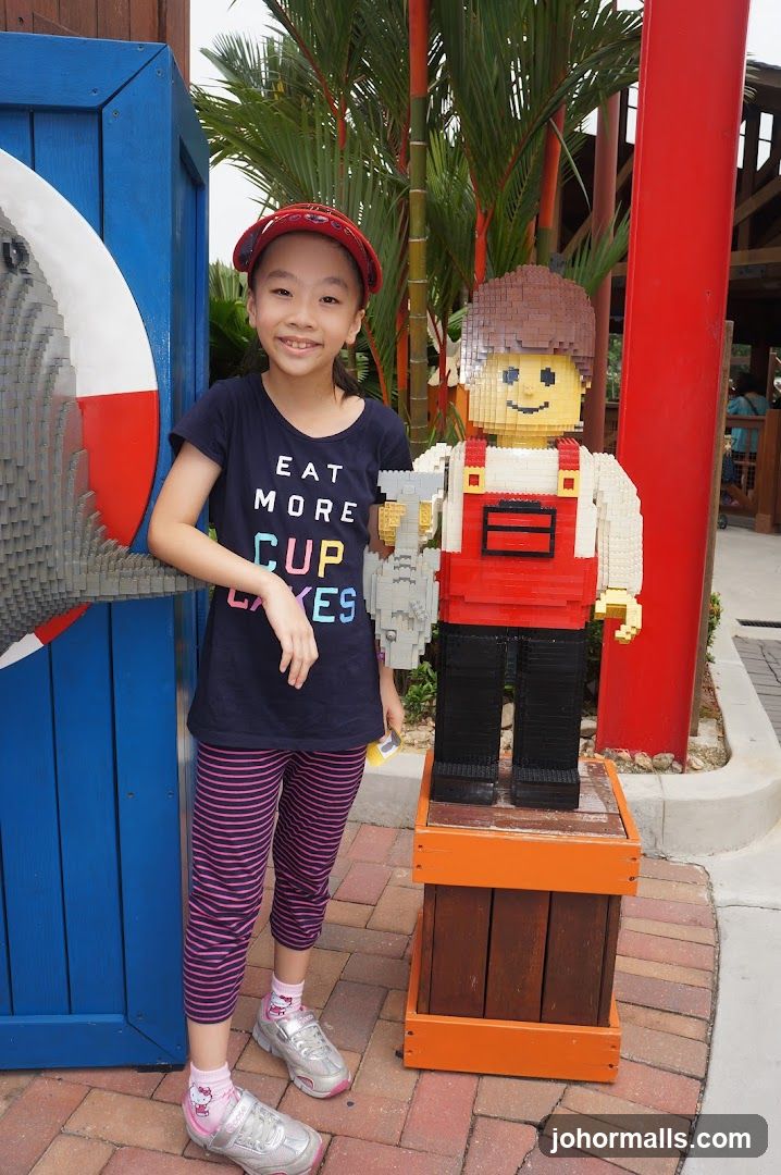 Girl Poses Next to Lego Figure