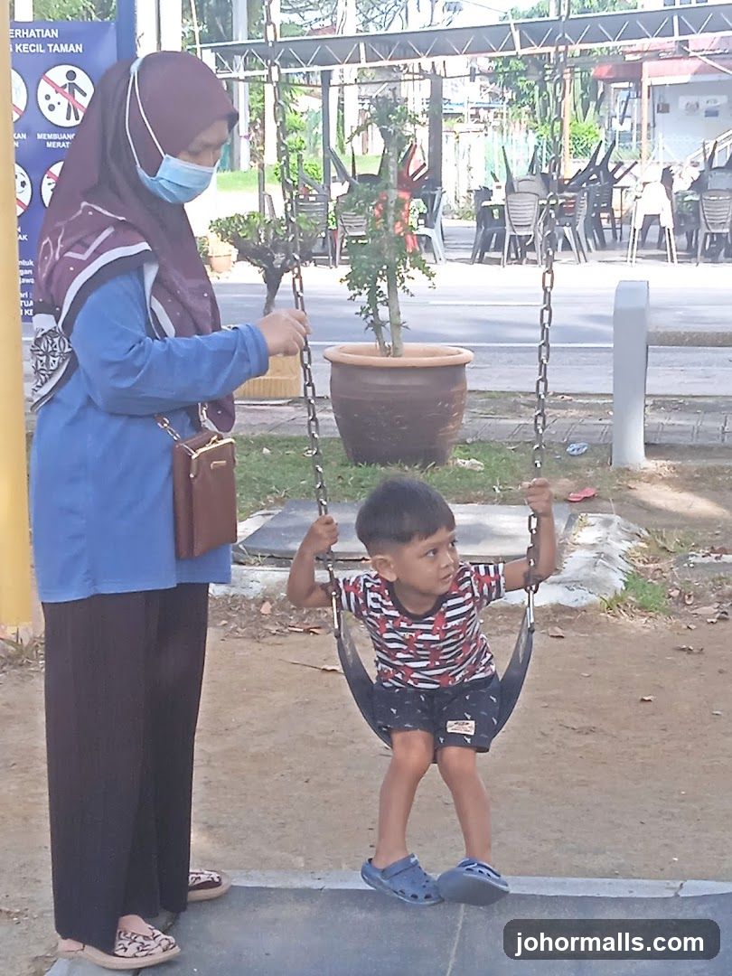 Woman pushing child on swing