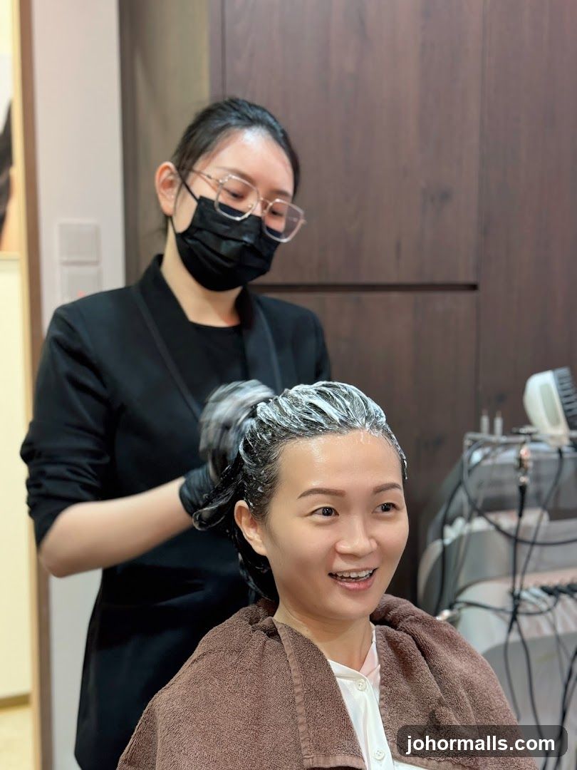 Hairdresser applying treatment to client's hair