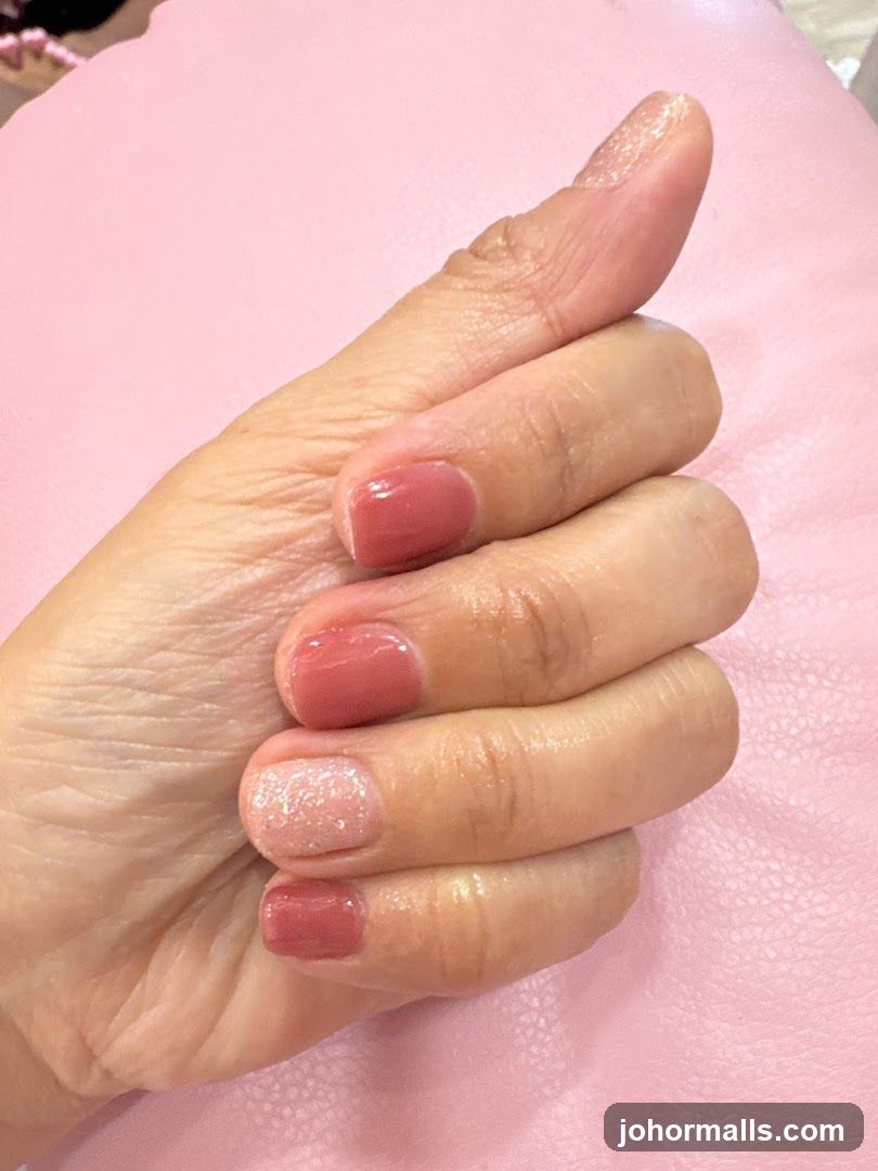 Manicured Hand with Pink and Glitter Polish