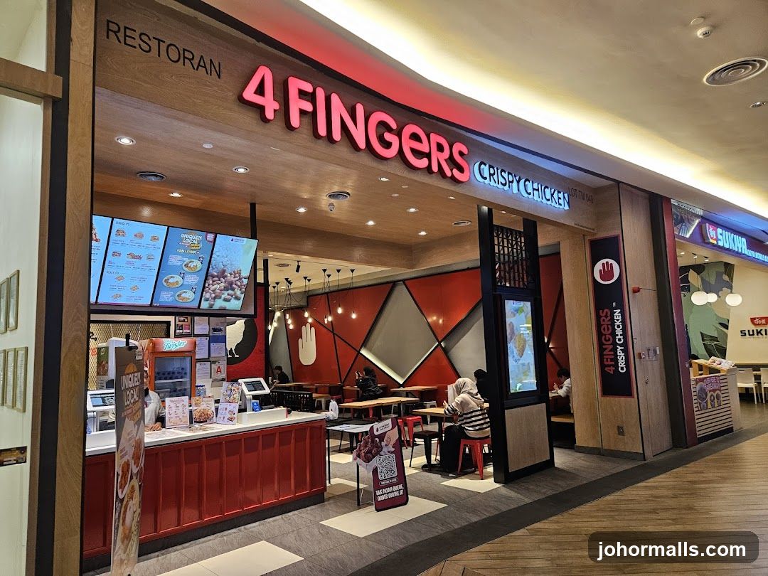 The exterior of a 4 Fingers Crispy Chicken restaurant. The restaurant has a wooden facade with a prominent red neon sign that reads "4 FINGERS CRISPY CHICKEN". Below the sign, there is a counter with a menu board displaying food items. Inside, tables and chairs are visible, along with red geometric wall decorations.