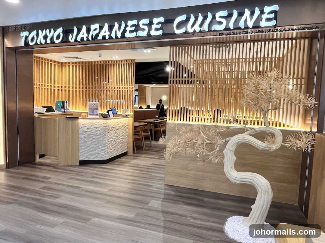 The exterior of a Japanese restaurant with a prominent sign reading "TOKYO JAPANESE CUISINE". The entrance features a reception desk and is decorated with wooden slatted panels and a stylized tree sculpture.