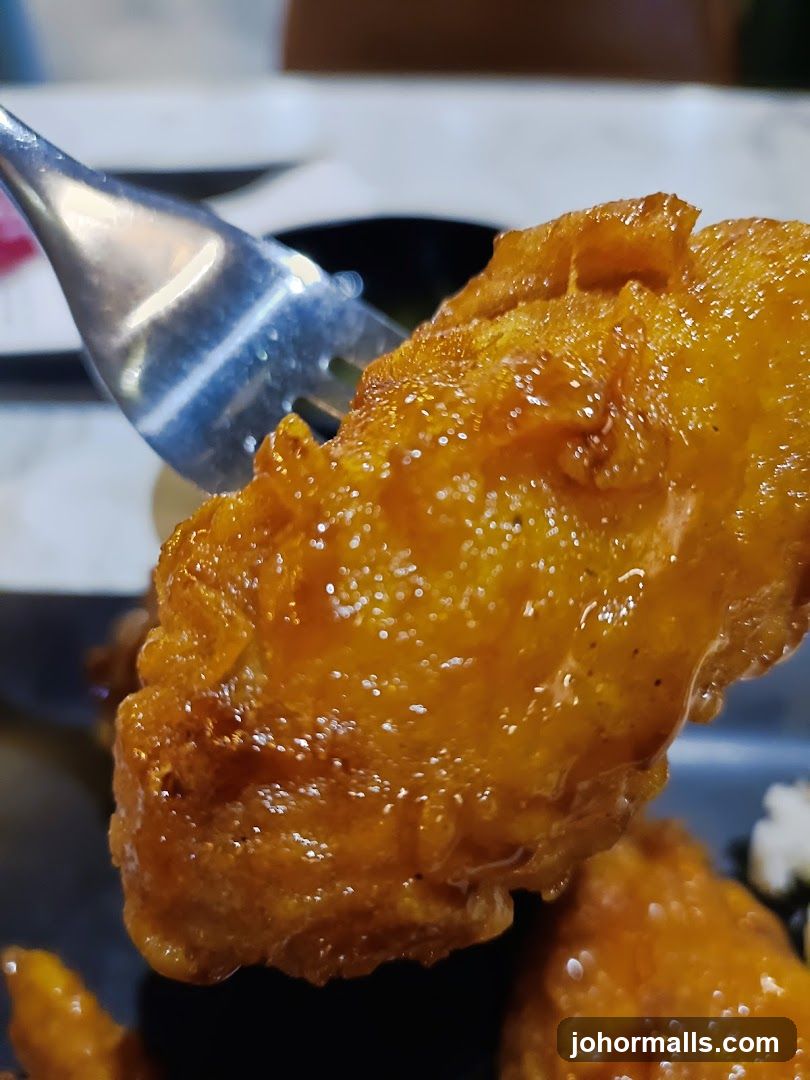 Close-up of a glazed chicken wing on a fork