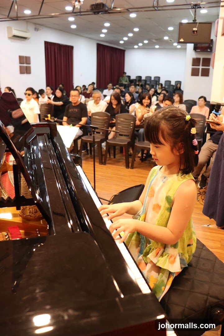 Child Playing Piano in Auditorium