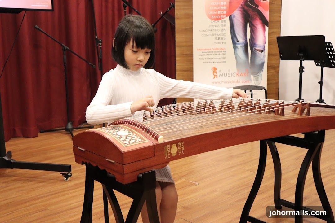 Child playing guqin in music studio