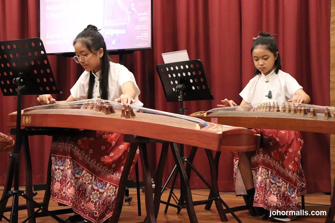 Two young girls performing with guzheng