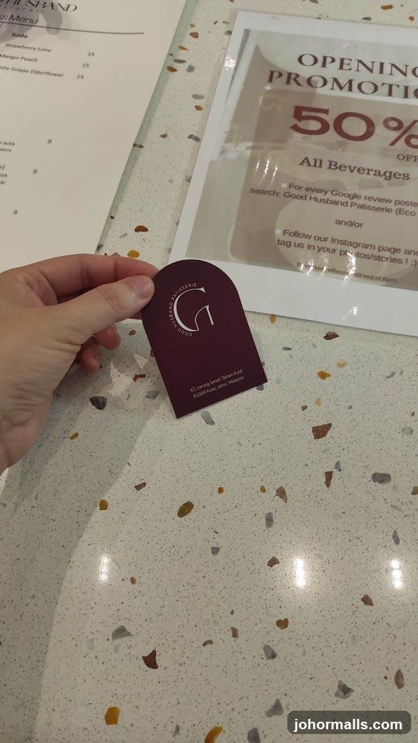 Hand holding branded card on counter