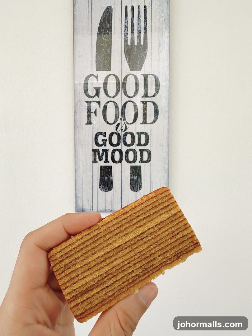 Hand holding food item in front of wall decor