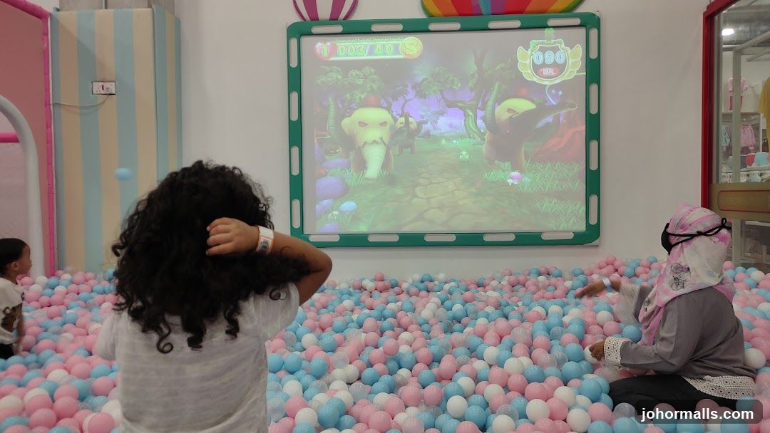 Children in ball pit watching game screen