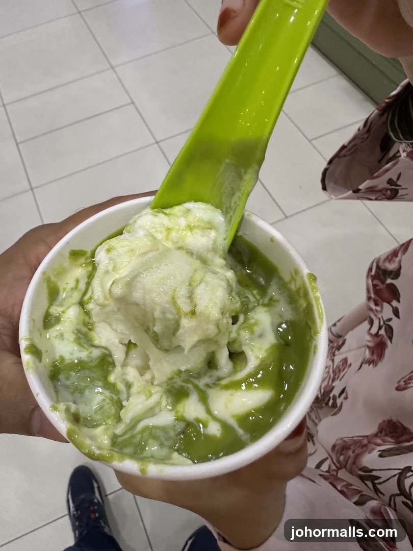 Hand holding green ice cream with spoon