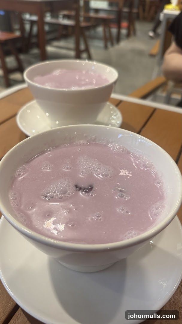 Two bowls of purple beverage on wooden table