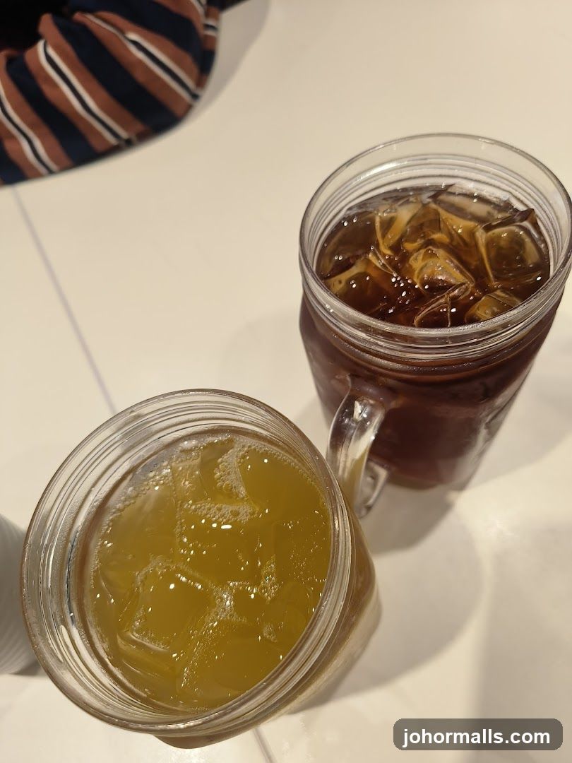 Two iced beverages in mason jars on a table