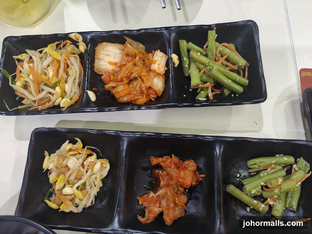 Korean side dishes served on black trays