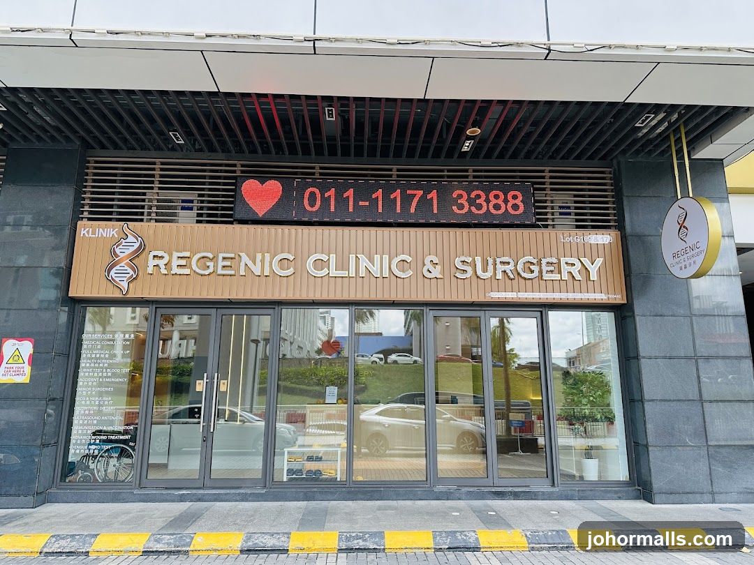 Modern clinic entrance with glass doors and a wooden sign displaying "REGENIC CLINIC & SURGERY" alongside a DNA helix logo. Above the main sign is an LED display showing a red heart icon and phone number 011-1171 3388. A circular hanging sign to the right also features the clinic's name and logo. The facade includes dark gray stone pillars, a black slatted ceiling above, and yellow-and-black striped curb in front.