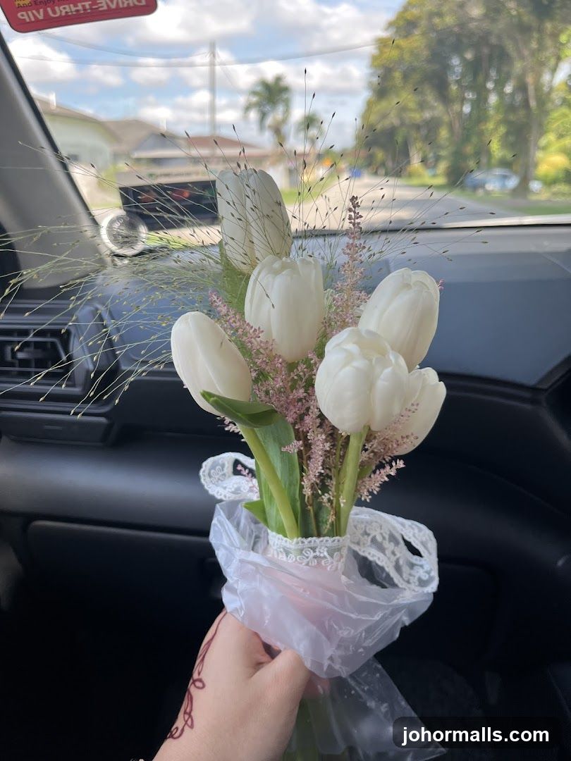 Hand holding flowers in car interior
