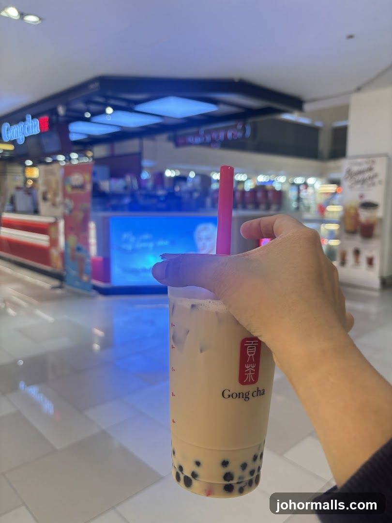 Hand holding Gong cha bubble tea in shopping mall