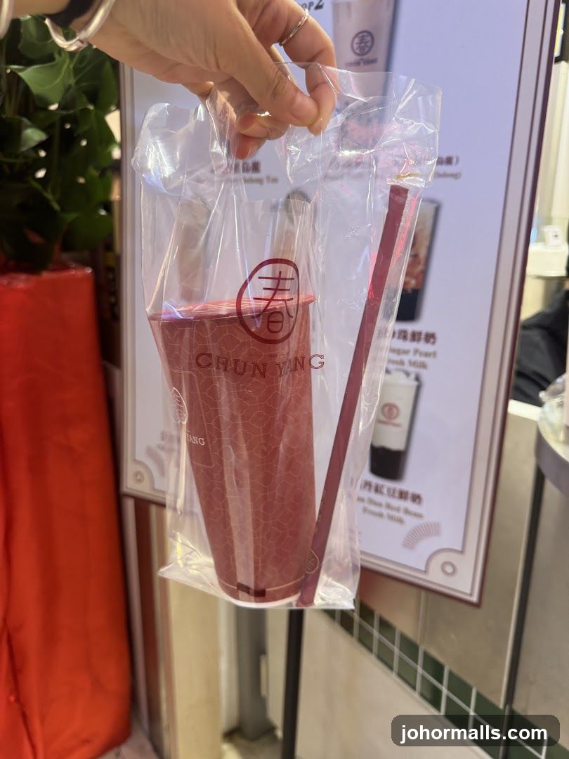 Hand holding drink cup in plastic bag