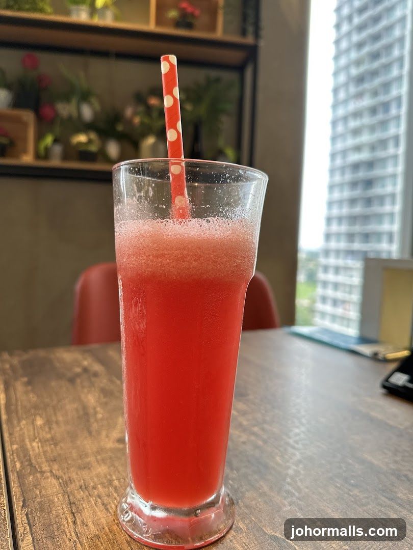 Red beverage in glass with polka-dot straw