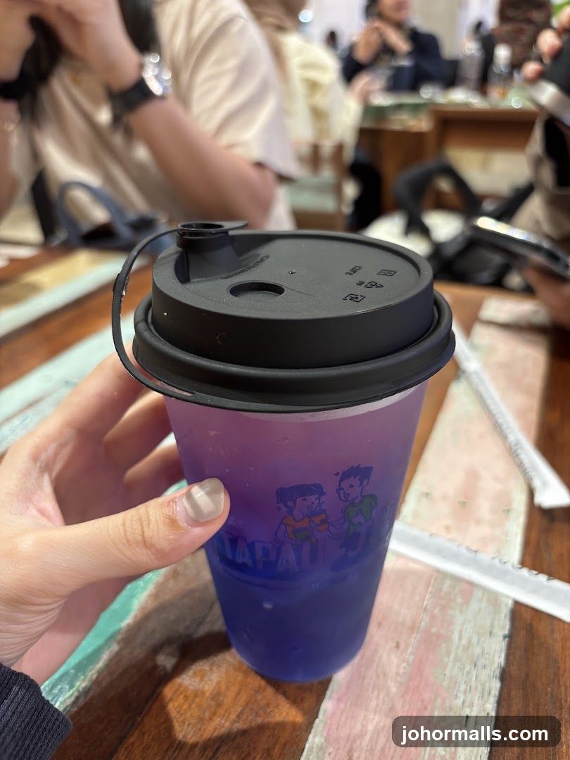 Hand holding a purple drink cup