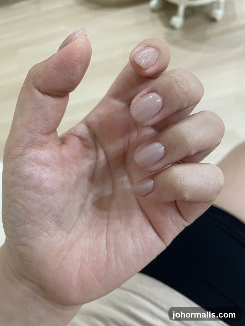 Close-up of a hand with light pink gel nails
